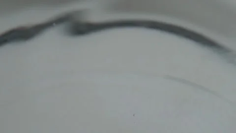 Macro close up of liquid droplet creating ripple on surface with slow motion Stock Footage 341431237