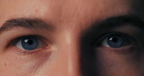 Macro close-up of man's beautiful blue eyes opening them slowly gaze serious 動画素材 229272312