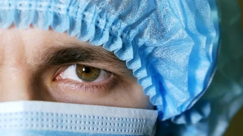 Macro close up of man's surgeon eye, doctor with face mask ready for operation Stock Footage 102975325