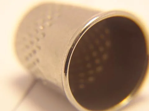 Macro close‑up of a metallic thimble with detailed texture 写真素材