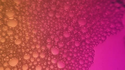 Macro close-up of numerous small bubbles on a pink and orange gradient Stock Footage 331941715