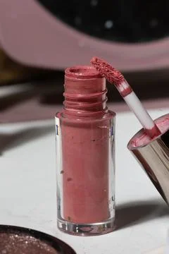 Macro close-up of an open lip gloss bottle with the wand resting at the openi Stock Photos