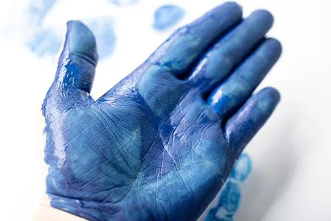 Macro close-up of an open palm covered in blue paint with. Fotos de archivo