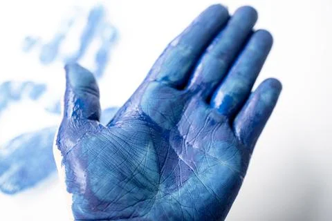 Macro close-up of an open palm covered in blue paint with. Fotos de archivo