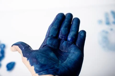 Macro close-up of an open palm covered in blue paint with. Fotos de archivo