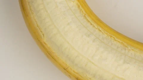 Macro Close Up Peeled Banana Texture Rotating On White Background 4K Stock Footage 322135306