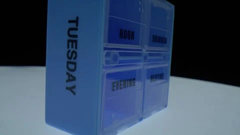 Macro close up of a pill organizer labeled evening and bedtime with Tuesday Stock Footage 326301183