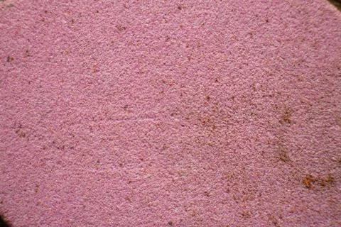 Macro close up of a pink grinding stone wheel abrasive surface texture 库存照片