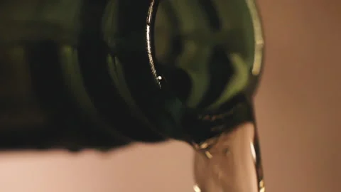 Macro close-up pours beer from a bottle on a light background Stock Footage 144666799