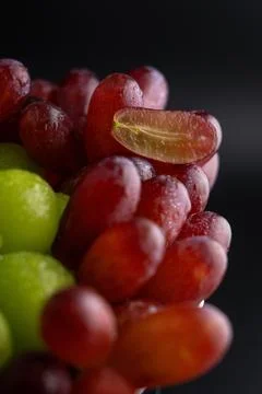 Macro Close-Up of Red and Green Grapes with Water Drops and Sliced Grape Foto stock