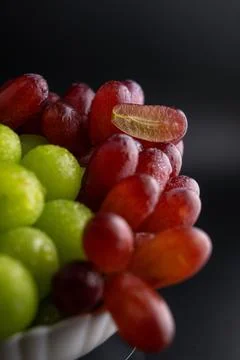 Macro Close-Up of Red and Green Grapes with Water Drops and Sliced Grape Foto stock