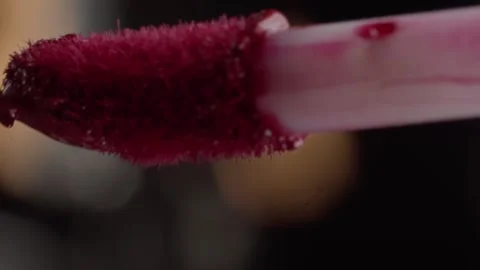 Macro close up of red makeup brush bristles attached to a pale pink cosmetic Vidéo 343710692