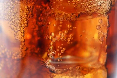 Macro close up of refreshing cola soda with ice cubes and carbonation bubbles Stock-Fotos