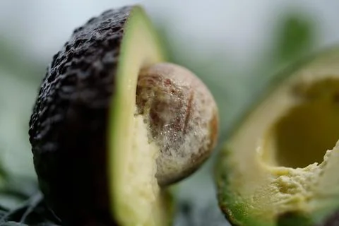 Macro close up of ripe avocado split open with seed exposed, revealing dark Stock-Fotos