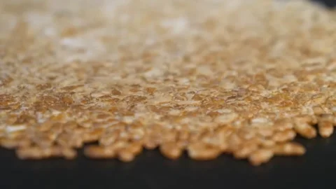 Macro Close-Up of Scattered Golden Brown Grains on Black Background Video stock 343028574