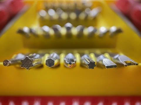 Macro Close Up Of Screwdriver Bit Set On Yellow Background Tool Kit Concept Foto stock