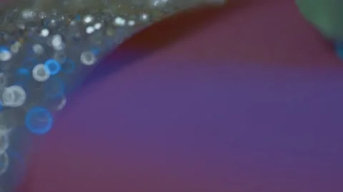 Macro Close-Up of Shimmering Glitter on Iridescent Surface Stock Footage 325375075