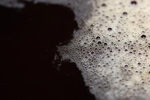 Macro close-up shot of dark coffee crema with rich bubbles and foam Stock Photos
