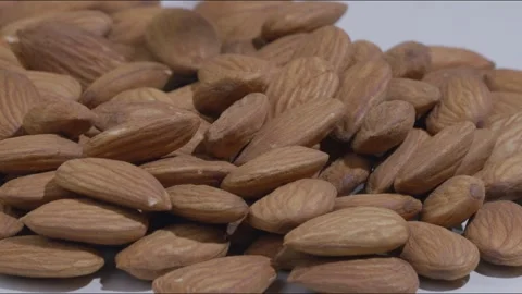 Macro close up shot of portion of unshelled almonds and more being placed Stock Footage 280338140
