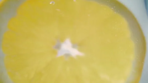 Macro close up shot of a slice of orange floating in water in slow motion Stock Footage 273121834