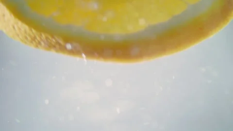 Macro close up shot of a slice of orange floating in water in slow motion Stock Footage 273121849