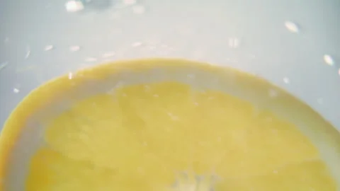 Macro close up shot of a slice of orange floating in water in slow motion Stock Footage 273121855