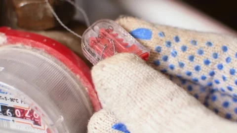 Macro close-up showing technician inspecting tamper-evident seal on residential Stock Footage 309619509