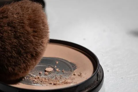 Macro close-up shows worn powder, crushed fragments, and a dirty brush on a n Stock Photos