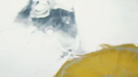 Macro close up of a slice of Orange  splashing in water in slow motion Stock Footage 273121818
