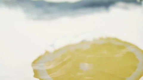 Macro close up of a slice of Orange  splashing in water in slow motion Stock Footage 273121819