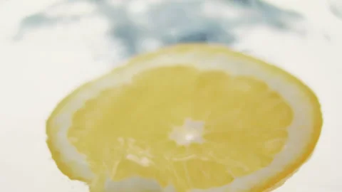 Macro close up of a slice of Orange  splashing in water in slow motion Stock Footage 273121820