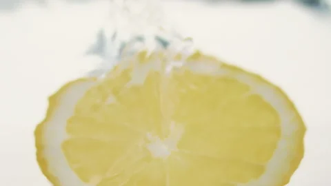 Macro close up of a slice of Orange  splashing in water in slow motion Stock Footage 273121821