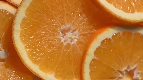 Macro Close-Up of a Spinning Orange Slice with Flying Segments Video stock 328281595