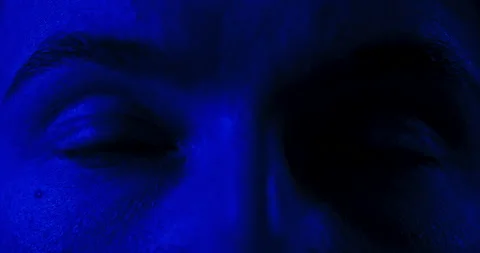 Macro close-up on terrified eyes, alternating blue and red strobe led light Stockbeeldmateriaal 229280387