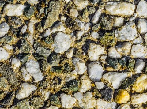 Macro close up texture of a pavement made of all kinds of tiny rocks beautifu Stock Photos