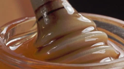 Macro Close Up of Thick Amber Syrup Being Stirred in Glass Container 스톡 동영상 345101276