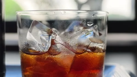 Macro close-up tracking shot of iced cold brew coffee in glass with condensation Stock Footage 344746816