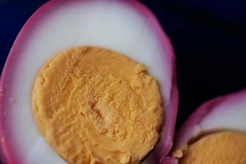 Macro close-up of two halved pickled eggs with vivid pink. 스톡 사진