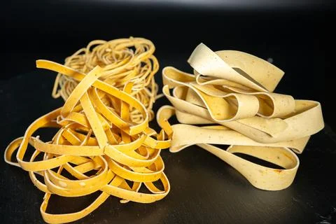 Macro close-up of uncooked ribbon pasta nests with rich. Stock Photos