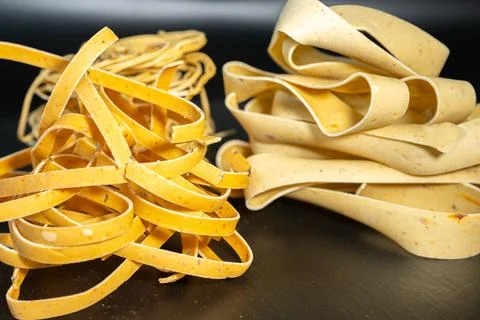 Macro close-up of uncooked ribbon pasta nests with rich. Stock Photos