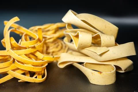 Macro close-up of uncooked ribbon pasta nests with rich. Stock Photos