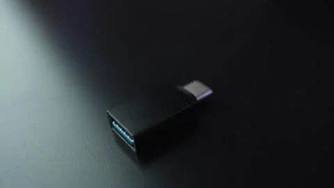 Macro close-up of a USB-A 3.0 to USB-C adapter on a dark desk with shallow Stock Footage 329479514