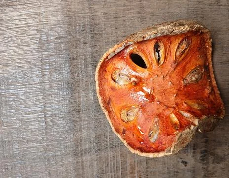 Macro close up of vibrant dried bael fruit slice on vintage rustic wood table Stock Photos