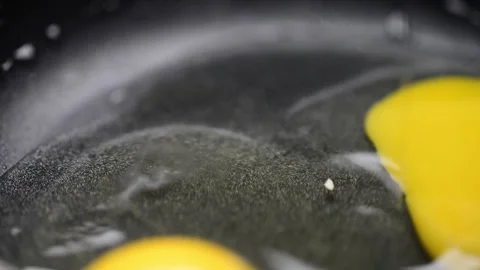 Macro close-up video of eggs being fried in a pan, showcasing sizzling, gol.. Stock-Footage 276453910
