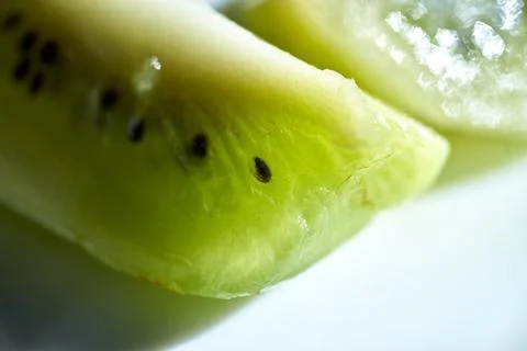 Macro close-up view of fresh green kiwi fruit slices showing tiny seeds Stock Photos
