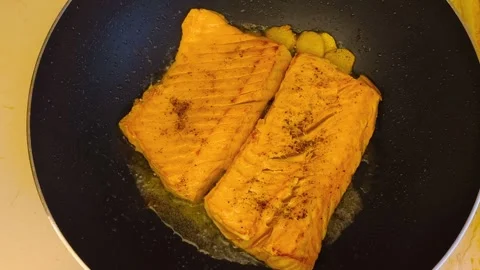 Macro close-up view of fresh hot sizzling fried salmon cooked in a dark fry.. Stock Footage 318254547