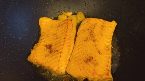 Macro close-up view of fresh hot sizzling fried salmon cooked in a dark fry.. Stock Footage 318254608