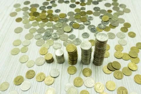 Macro close up view of a stack of coins on a pile of banknotes. Currencies or Stock Photos