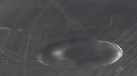 Macro close up water drop impact and ripple on brushemtal slow motion Stock Footage 55806068