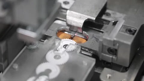 Macro close-up of white plastic gear wheels and orange tape reel being Stock Footage 337889411